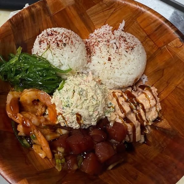 Kanaka poke bowl with rice, seaweed salad, shrimp, crab salad, spicy tuna, and ahi poke.