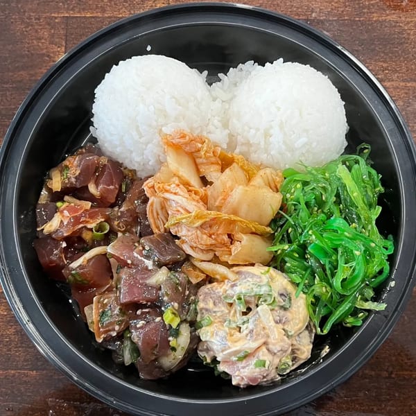 Kanaka poke bowl with two scoops of rice, kimchi, seaweed salad, and two types of poke.